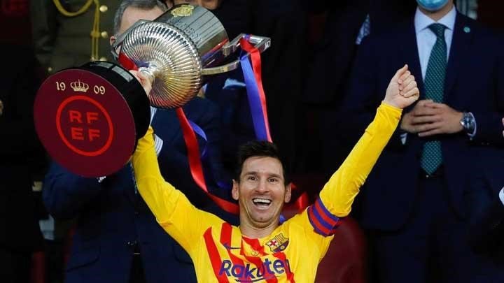 Pemain Barcelona, Lionel Messi mengangkat trofi kemenangan Copa del Rey di Stadion La Cartuja, Spanyol 17 April 2021 (Sumber: handout via Reuters, 2021)